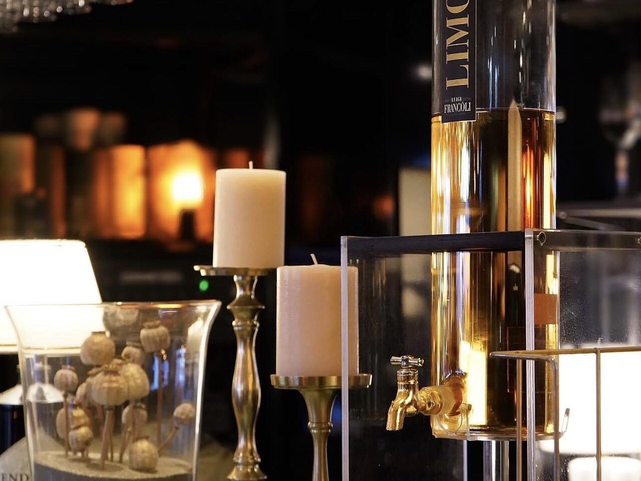 Le bar du Restaurant L’Étoile à Lausanne, verres suspendus et bougies allumées en soirée