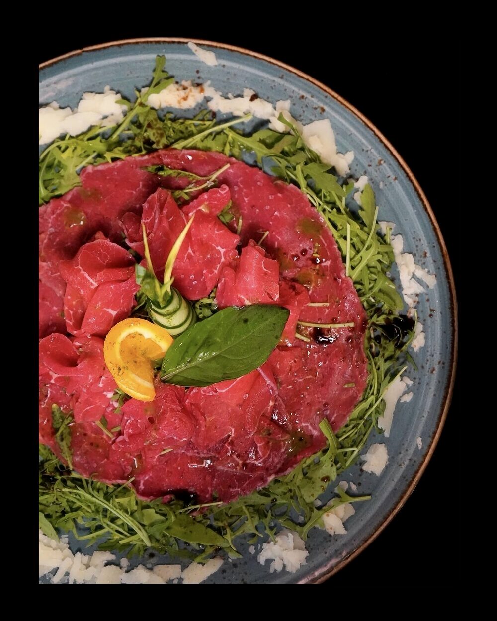 Carpaccio de bœuf, roquette et écailles de Grana Padano, servi au Restaurant L’Étoile