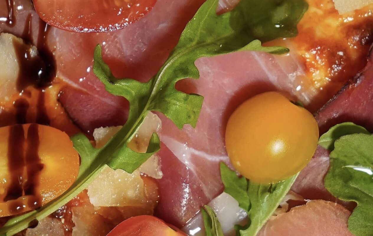 Pizza au jambon cru, roquette et tomates cerises, sortie du four